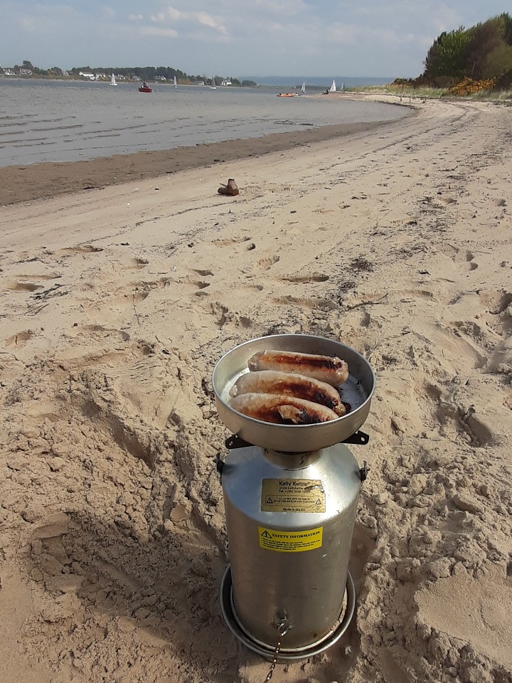 Sausages in the sun thanks to our Kelly Kettle. (Findhorn Bay, Scotland)