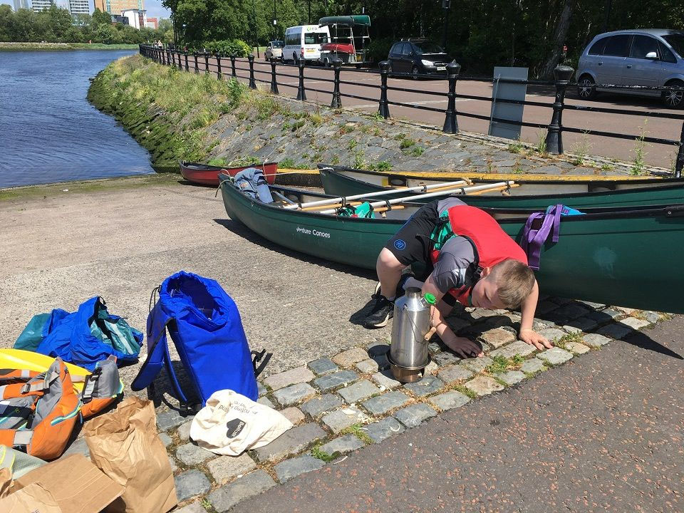 One of our young people making a brew after a hard days paddle with a Kelly Kettle on the River Lagan in Belfast, Northern Ireland
